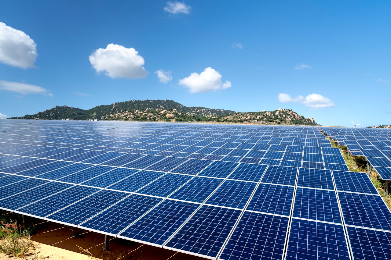 A sprawling solar farm with blue solar panels under a vibrant sky, showcasing renewable energy.